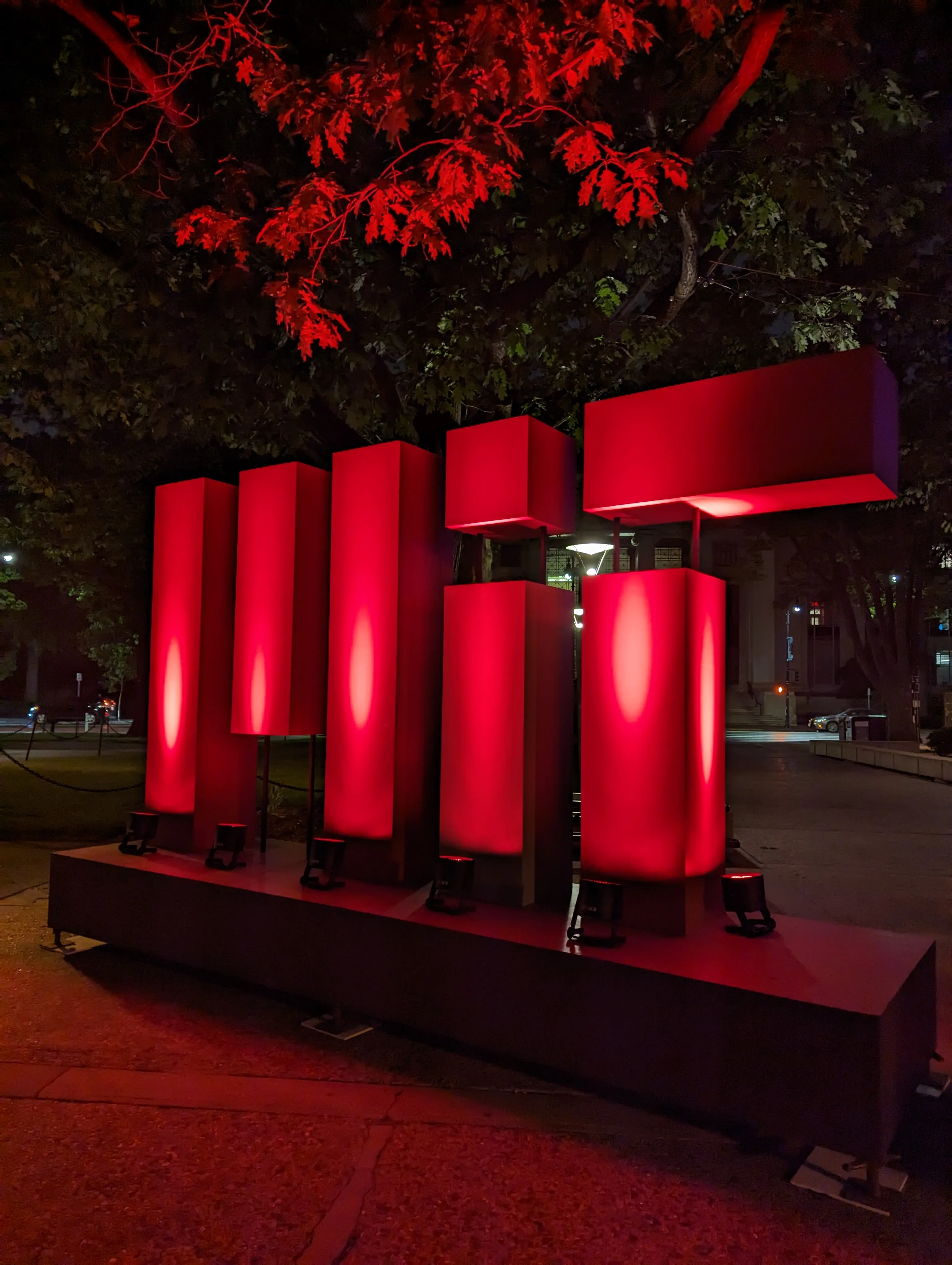MIT logo lit up by red lights at night